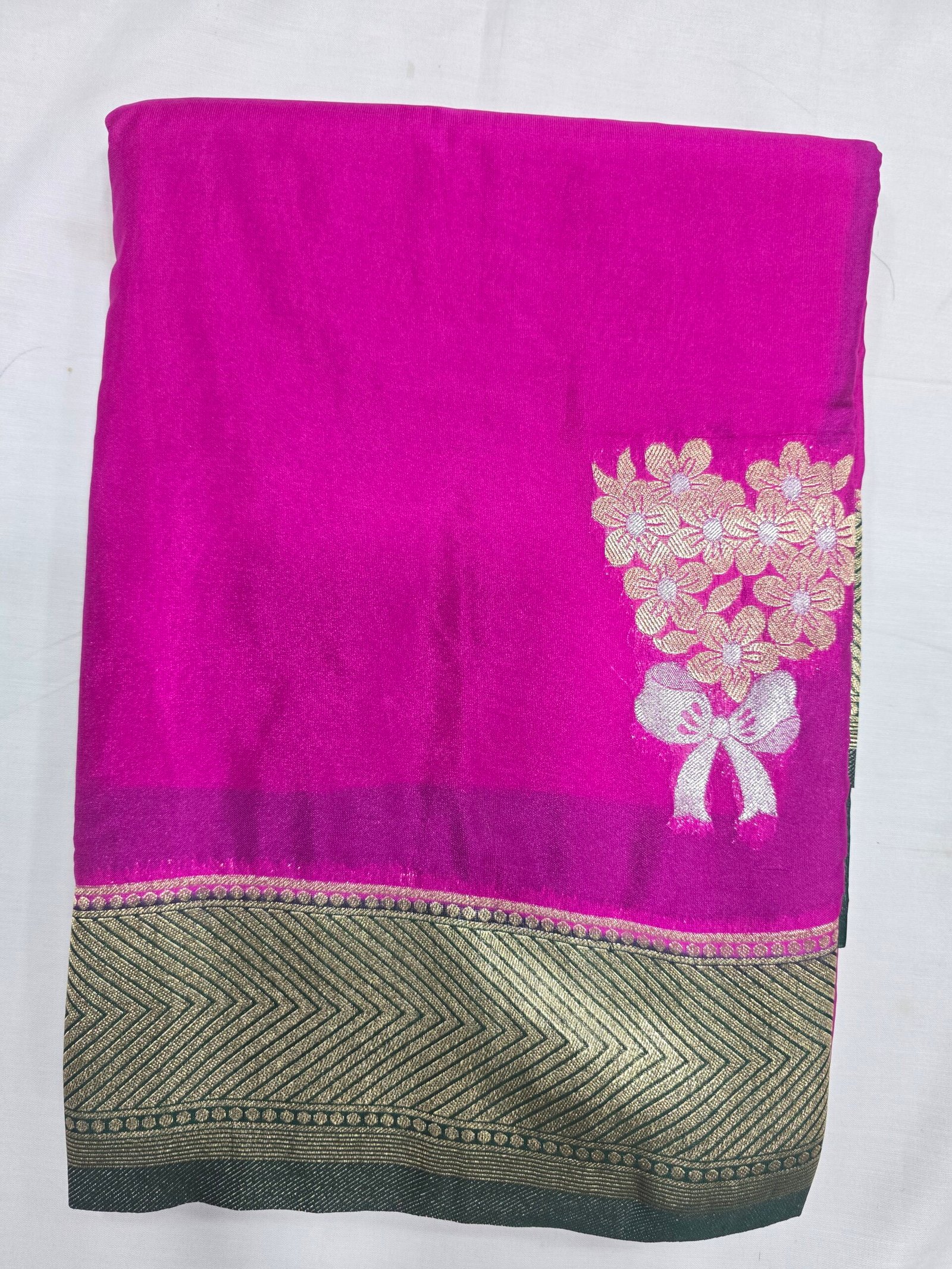 Soft Silk Saree, bright pink fabric with a gold floral motif and dark border.